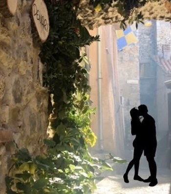 Vicolo sotto un arco ricoperto di vite