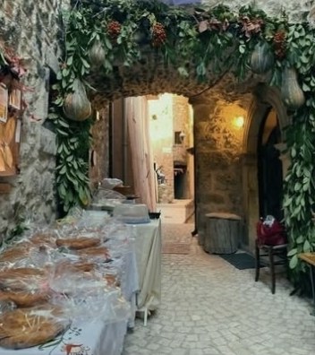 Un arco in pietra decorato con tralci, con le pizze esposte sul tavolo