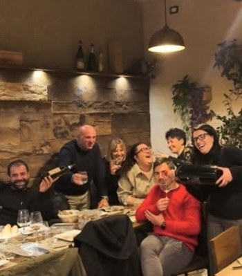 Una tavolata di amici in cantina